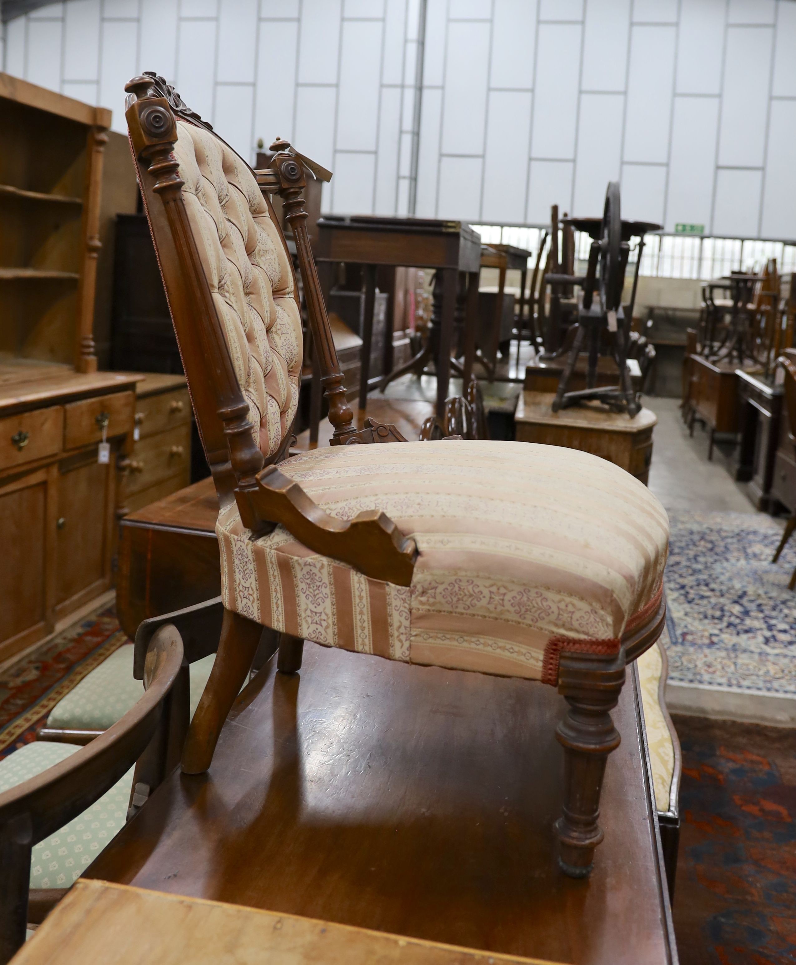 A small late Victorian carved walnut sewing chair, with buttoned back and turned legs, width 53cm, depth 50cm, height 80cm